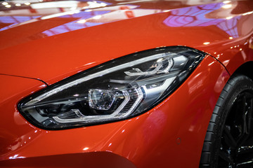 Headlight of orange modern car with LED light