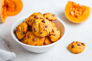 Pumpkin cookies with chocolate chips made from cake mix in a white ceramic bowl.
