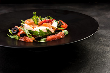 Healthy salad on dark plate.Restaurant dish,healthy eating