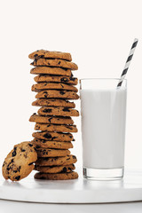delicious chocolate cookies near glass with straw and milk isolated on white