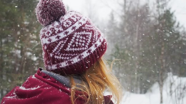 Woman backpacker in a winter hike snow forest trail national par Young girl enjoy snow falling . Happy winter holidays active lifestyle concept.