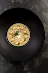 Homemade mushroom cream soup served on dark plate
