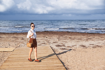 Girl poses on the beach against the sea.