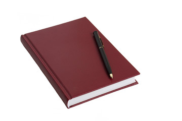 The burgundy notebook and black pen lie on a white table.