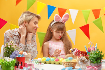 happy family mother and child girl paints eggs for Easter at home. Family celebration and home decoration for spring holiday.