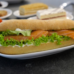 Big sandwich with salad and fish. Fish Salmon in a sandwich. Fish sandwich. Photography food close up
