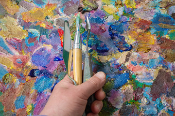 paint brushes in man hand