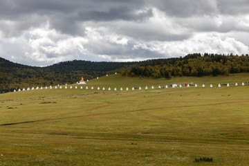 Obraz premium Buddhist monastery in Mongolian steppe, Stupas along the wall of a Mongolian monastery, Bornuur, Mongolia.