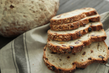 Sliced  raisin  bread on black background. Crumbs and fresh Bread slices close up. Bakery, food concept. Top view .Fresh large homemade bread