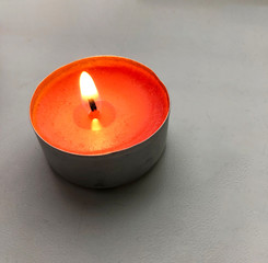 burning red candle on a white windowsill