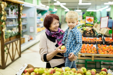 Grandmother and grandson choosing Apple fruit during shopping at vegetable supermarket