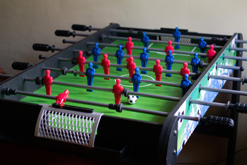 Picture of a table football game with a green pitch and blue & red players