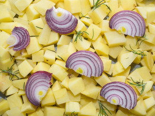 chopped raw potatoes with red onion slices and rosemary leaves