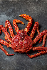 Red king crab on gray background. King crab, lemon and cilantro, top view
