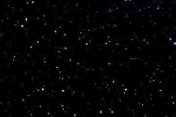 Falling snow on black background Snowflakes Flying in the air.
