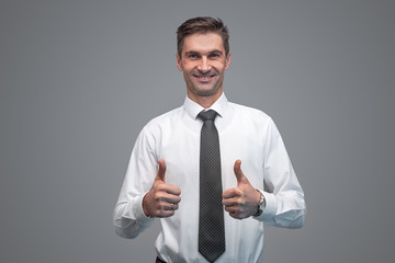 Smiling businessman gesturing thumb ups