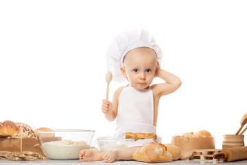 Small kid as a little cook or scullion make pizza in chef suit. Cooking child lifestyle concept. Toddler playing