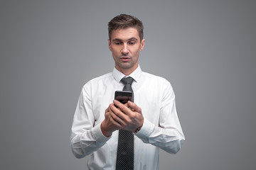 Surprised businessman using smartphone