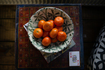 A patterned fruit bowl full of clementines/oranges