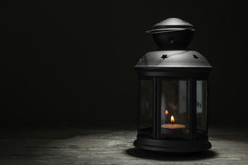 Ramadan or arabic lantern on wooden table against dark background