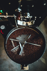 Coffee roasting in small roastery. Coffee roasting machine, Production of coffee.
