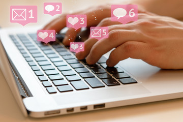 People chatting with friends in social networks or media. Can be used as an illustration for news, marketing or business concept. Hands and laptop with black keys. Daytime natural lighting.