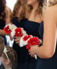 Bridesmaids at a wedding holding red and white flower bouquets