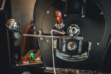 Fototapeta premium Coffee roasting in small roastery. Coffee roasting machine, Production of coffee.