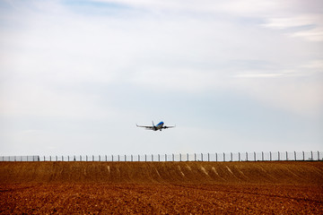 Fototapeta na wymiar plane takes off above a farmed field