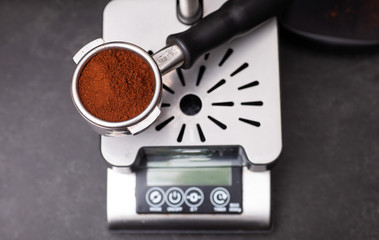 A Group head full of freshly ground coffee being weighed ready for the espresso machine