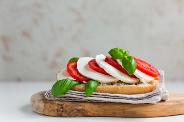 Caprese sandwich: Mozzarella, tomatoes, basil leafes, italian bread, olive oil. Olive oil bottle. white background