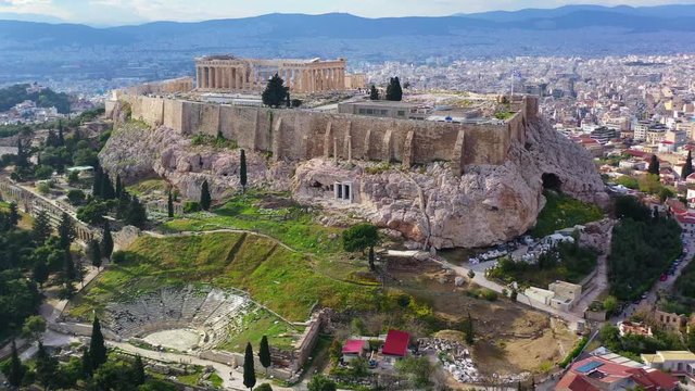 Aerial drone bird's eye view video of iconic Acropolis hill masterpiece of Western civilisation, the Parthenon and famous theatre of Dionysus, Athens historic centre, Attica, Greece