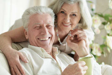 Close up portrait of two elderly people resting at home with tea