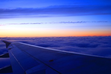Fototapeta na wymiar Sunrise from the airplane, high above clouds