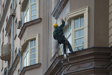 Industrial Alpinism. Workers wash the windows in the street