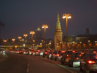 Fototapeta na wymiar Red Moscow Kremlin Towers and traffic jam nearby at the sunset time. Ministry of Foreign Affairs as background.