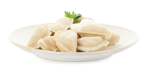 Fototapeta na wymiar Plate of tasty dumplings with sour cream and parsley isolated on white