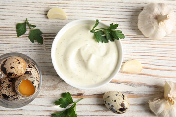 Flat lay composition with garlic sauce on wooden background