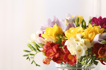 Beautiful bouquet of spring freesia flowers on light background, closeup. Space for text