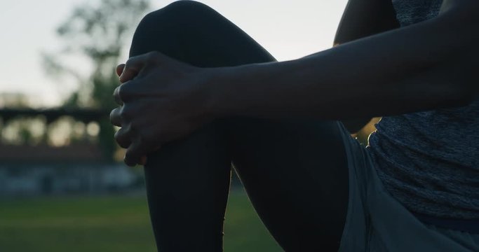 Slow motion close up of young african male athlete is warming up for start the training race in athletics stadium with sunshine.