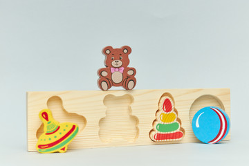 Background of children's colorful wooden toy figures for children on a light background. vertical view close-up.