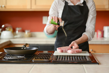 The chef prepares fresh pork steaks in the kitchen, peppers meats on the menu, home cooking. culinary recipes. restaurant menu.