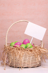 Easter eggs a in a wicker basket and a blank sign