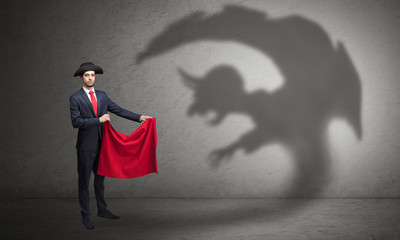 Businessman standing with red cloth in his hand and imp shadow on the background
