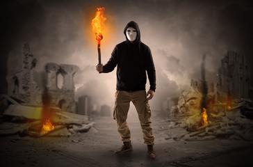 Obraz premium Destroyed place after a catastrophe with man and burning flambeau concept 