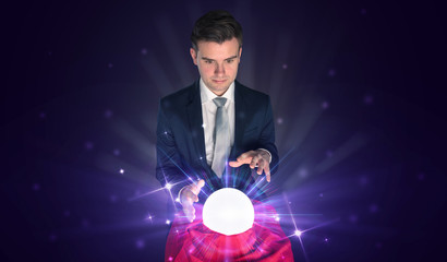 Young businessman sitting with crystal ball in action