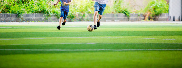 blurry Kid soccer and dad are playing ball on at artificial turf