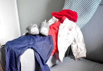 Baby toddler clothes ready for wearing set out on chair and dresser change table