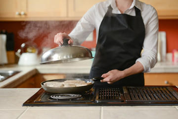 The chef prepares fresh pork steaks in the kitchen, home cooking menu. culinary recipes. restaurant menu. Delicious food, recipes and cooking