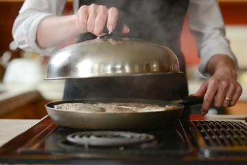 The chef prepares fresh pork steaks in the kitchen, home cooking menu. culinary recipes. restaurant menu. Delicious food, recipes and cooking